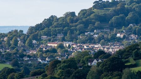 A view of the Cotswolds town of Alderley nestled in the trees and hills.