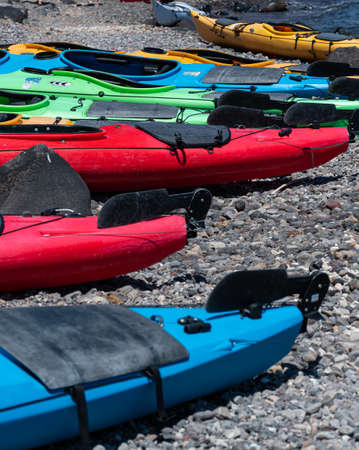 Akrotiri, Greece - July 19 2019:   A group of brightly coloured canoes on the stony beach of Akrotiriのeditorial素材