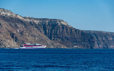Aegean Sea, Greece - July 16 2019:   A Minoan Lines Ferry gliding past the cliffs of Santorini in the Aegean Seaのeditorial素材