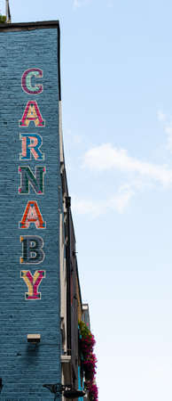 London, United Kingdom - August 18 2019:  A sign painted on teh side of a building indicating the entrance to London's famous shopping location, Carnaby Streetのeditorial素材