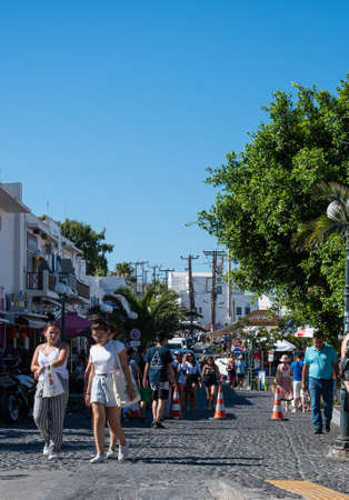Fira, Greece - July 12 2019:   Shoppers and tourists browse amongst the shops and stalls on Dekigala Roadのeditorial素材