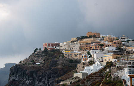 Fira, Greece - July 14 2019:   Houses and Hotels built on the very edge of the cliifs of Fira,...