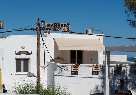 Fira, Greece - July 12 2019:   The sign and pole of a barber Shop on Dekigala Roadのeditorial素材