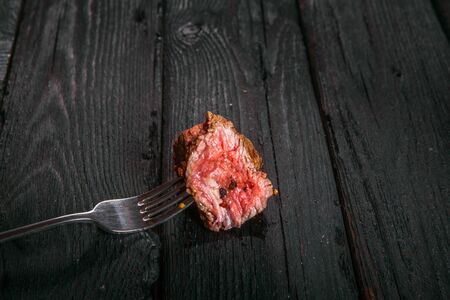 grilled meat. impale a piece of steak on a fork.の写真素材