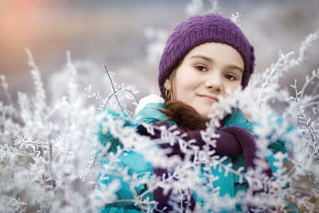 Beauty Winter Girl Blowing Snow in frosty winter Park