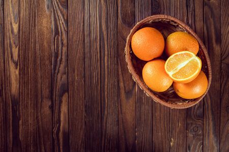 basket of fresh oranges on a wooden tableの写真素材