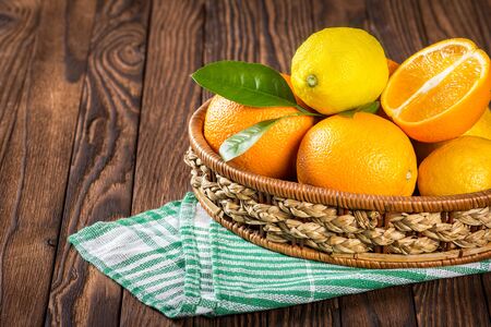 basket of fresh oranges on a wooden tableの写真素材