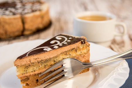 Chocolate cake, a slice of chocolate cake on a platter and a cup of hot tea