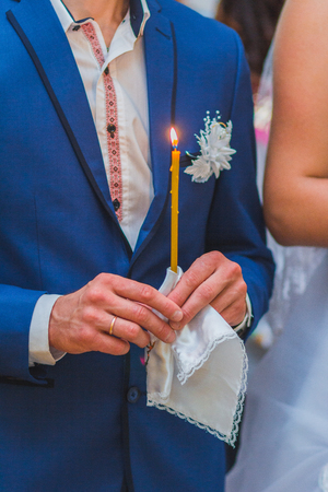 The groom and the bride with candle. Wedding ceremony in churchの写真素材