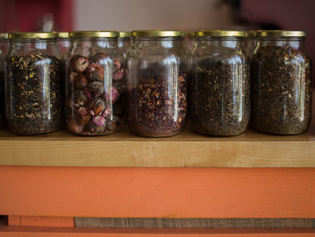 samples of loose leaves of green, red, black and herbal tea in glass jars