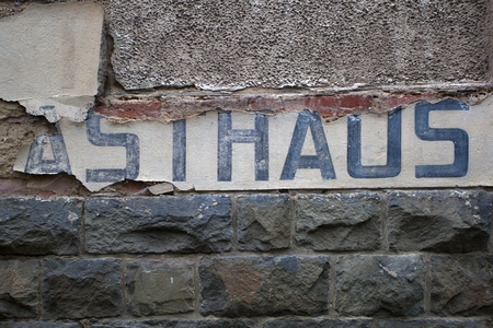 Stone crumbled wall with fallen off plaster and a Remains of an old sign.の写真素材