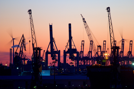 Silhouette of container of gantry cranes in the harbor of Hamburg, Germany at sunset.の写真素材