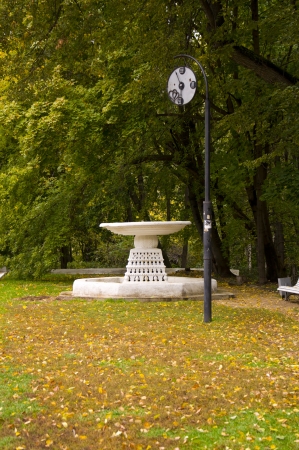 Clock and Fountain in autumn parkの写真素材