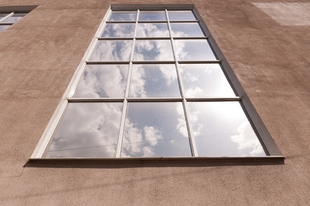 The window in which is reflected the sky with clouds
