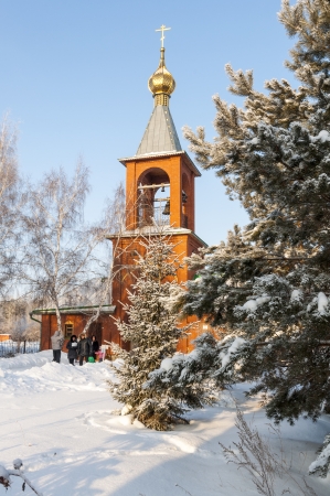 An old orthodox bell tower in winter forestの写真素材