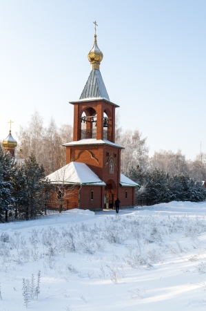 An old orthodox bell tower in winter forestの写真素材