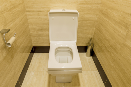 white toilet in a stall with the lid openの写真素材