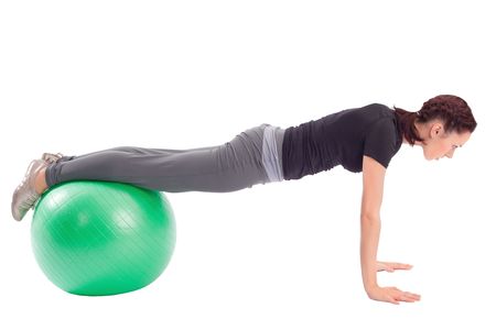 Young woman with gym ball doing pushup exercise, isolated on white background.の写真素材
