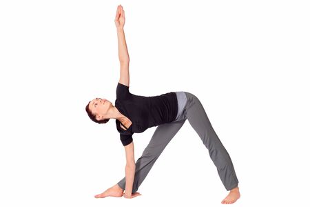 Young fit woman doing yoga exercise called Triangle Pose (Sanskrit name: Trikonasana), isolated on white background.の写真素材