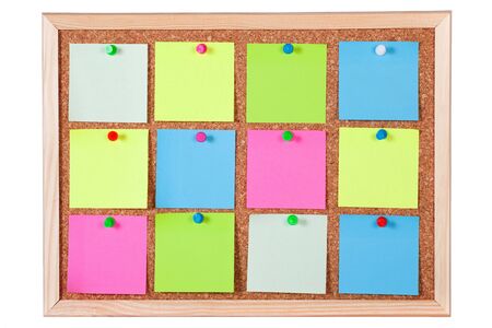 Pieces of blank colorful note papers on a cork bulletin board, isolated on white background.の写真素材