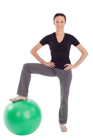 Young fit smiling pretty woman with gym ball, isolated on white background.の写真素材