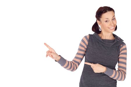 Young smiling woman in casual clothing showing something on the left, isolated on white background.の写真素材
