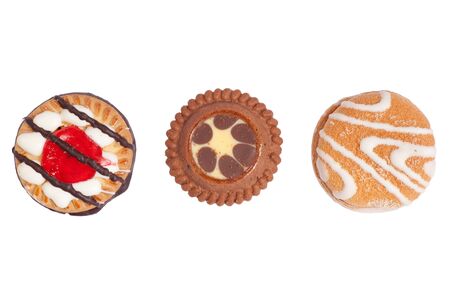 Three delicious sweet and crunchy biscuits cookies with jelly, icing and chocolate on top, isolated on white background.の写真素材