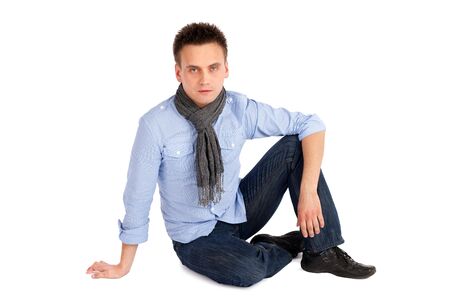 Casual attractive young man sitting on the ground, isolated on white background.の写真素材