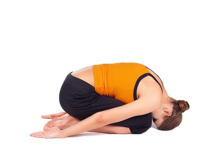 Fit woman doing yoga exercise called Child Pose, sanskrit name: Balasana, isolated over white backgroundの写真素材