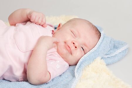 Content relaxed a little bit sleepy baby girl making a funny faceの写真素材