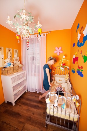 Wide shoot of a mother and child in a well designed small but comfortable baby roomの写真素材