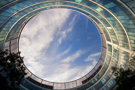 Sky in frame made by round modern office building の写真素材