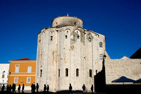 St. Donatus church in Zadar, Croatia, founded in the 9th century as the Church of the Holy Trinity, tourists group silhouette in the foregroundの写真素材