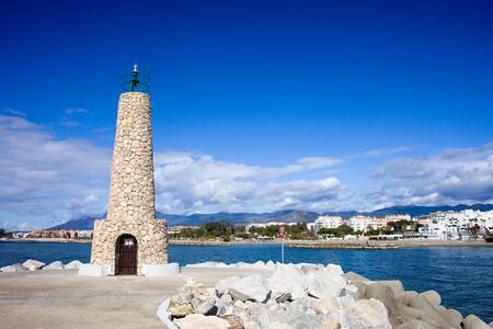 Stone lighthouse at the end of pier in Puerto Banus in Spain, southern Andalusia, Malaga province.の写真素材