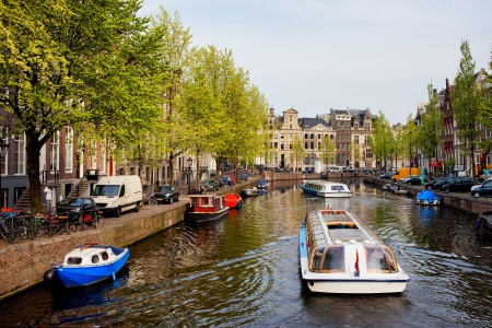 Passenger boats on canal tour in the city of Amsterdam, Holland.の写真素材