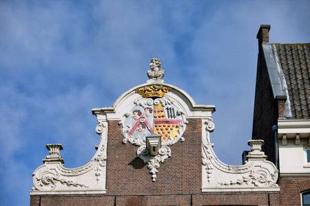 Ornate Dutch style neck gable with coat of arms on top of a 17th century house in the Old Town of Amsterdam, the Netherlands.のeditorial素材