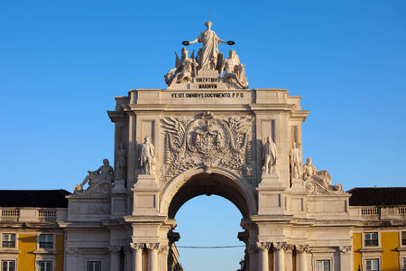 Rua Augusta Arch at sunrise in Lisbon, Portugal. Statues at the top: Allegory of Glory rewarding Valor and Genius, coat of arms of Portugal below.の写真素材