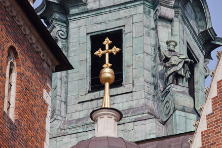 Gilded cross against bell tower window of the Wawel Cathedral in Krakow, Poland.の写真素材