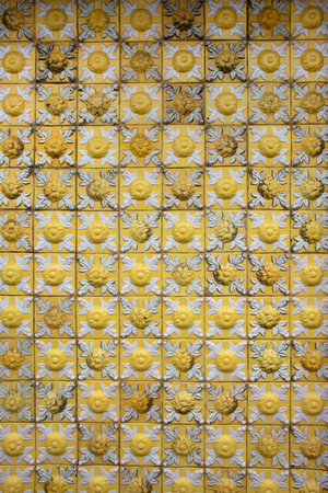 Old, aged, yellow, vintage ceramic tiles background or texture with flower motif.