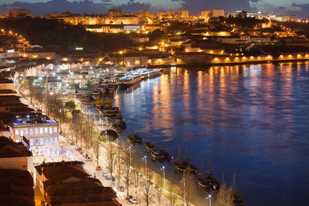 Vila Nova de Gaia cityscape and Douro river at night in Portugal.