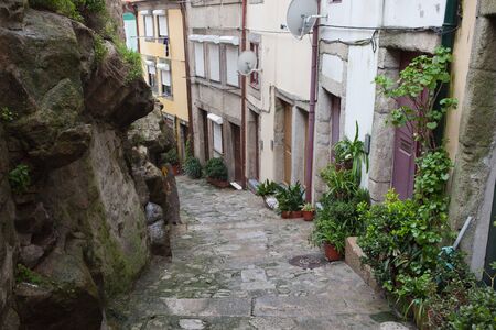 Traditional houses along descending narrow alley in the old town of Porto in Portugal.