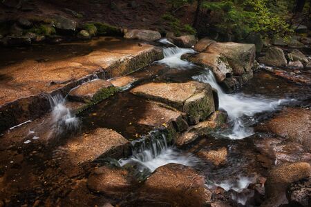 Creek in the mountains with boulders and small water cascadesの写真素材