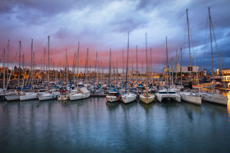 City of Barcelona in Spain, Port Vell at twilight, sailboats and yachts at Darsena Nacional Marinaのeditorial素材