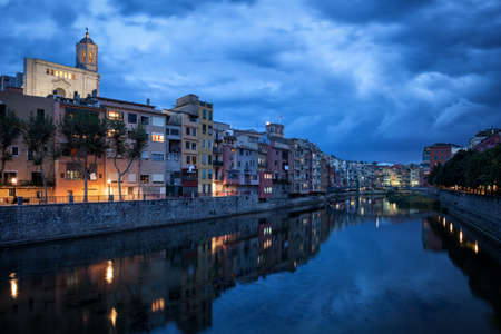 Spain, Catalonia, Girona city skyline at dusk, old houses at Onyar Riverの写真素材