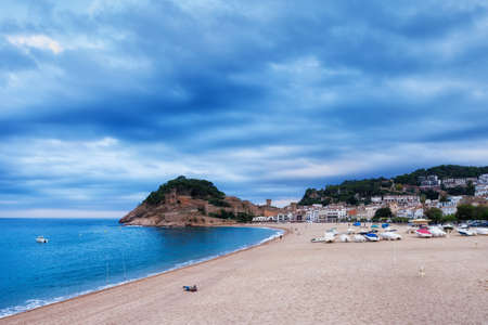 Beach in resort town of Tossa de Mar on overcast cloudy day, Costa Brava, Catalonia, Spainの写真素材