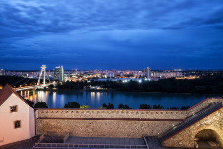 City skyline of Bratislava in Slovakia at blue hour twilight, view above castle wall and Danube river to Petrzalka district.のeditorial素材