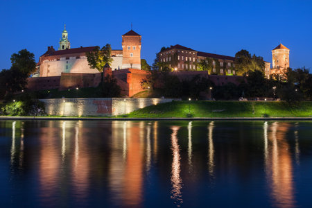 Wawel Royal Castle at night in Krakow, Poland, view across the Vistula River, city landmark.のeditorial素材