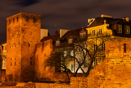 City wall fortification and houses at night in the Old Town of Warsaw in Poland.の写真素材