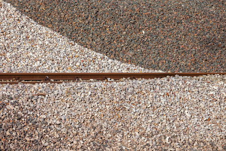 White and dark crushed stone piles background with rail trails in the middleの写真素材