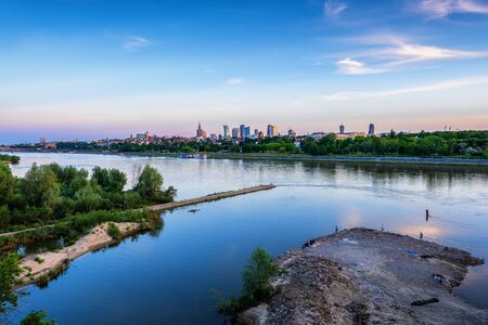 Vistula River and Warsaw skyline at blue hour twilight, capital city of Poland.
